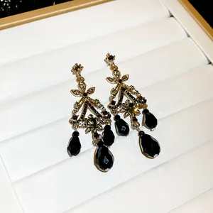 Détail rapproché de boucles d'oreilles vintage avec cristaux noirs et strass