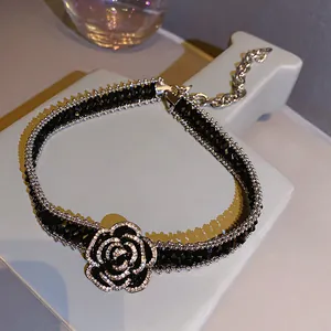 Vista macro di un choker a camelia nera in stile francese con dettagli in cristallo