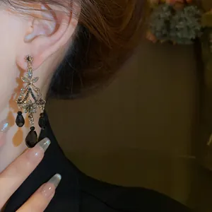 Gros plan détaillé de boucles d'oreilles vintage avec cristaux noirs sur l'oreille d'un mannequin