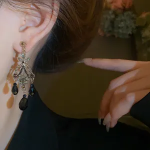 Gros plan de boucles d'oreilles élégantes à pampilles en cristal vintage portées à l'oreille.