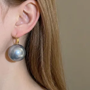 French style oversized grey metallic pearl earrings worn on ear for vintage look