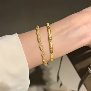 Detail view of elegant Italian gold twisted mesh bracelet and star-engraved bangle set.