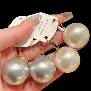 Close-up detail of oversized French pearl leverback earrings in silver and cream