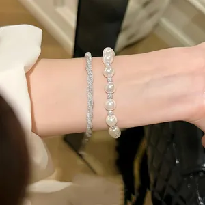 Close-up of elegant Italian mesh twisted bracelet and pearl bracelet on wrist