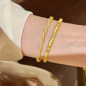 Detailed view of elegant gold twisted mesh bracelet and star-engraved crystal bangle