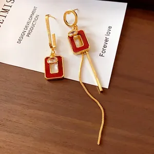 Eleganti orecchini asimmetrici con quadrati in smalto rosso e lunga nappa dorata