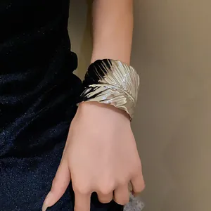 Detailed view of a shiny silver metallic leaf texture open cuff bracelet on wrist