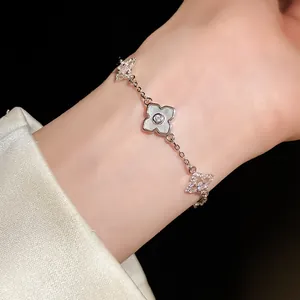 Nahaufnahme eines eleganten silbernen Zirkon-Kleeblatt-Armbands am Handgelenk mit Satin