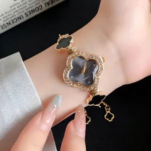 Elegante quarzuhr in kleeblattform mit schwarzem acetat und rhinestones am handgelenk