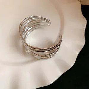 Detailed view of silver leaf textured metal cuff bracelet featuring a layered open design