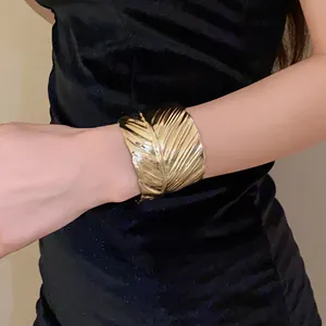 Close-up detail of a textured gold leaf cuff bracelet worn on the wrist for an elegant look.