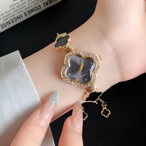 Nahaufnahme einer eleganten schwarzen Armbanduhr in Kleeblattform mit Strasssteinen