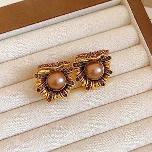 Vintage gold-plated flower stud earrings with champagne pearl and amber crystal rhinestones