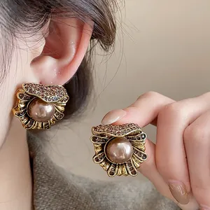 Close-up of vintage flower-shaped pearl earrings with rhinestones shown on model's ear