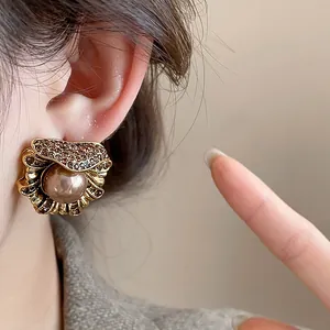 Detailed view of vintage court-style earrings featuring irregular flower petals and pearls.
