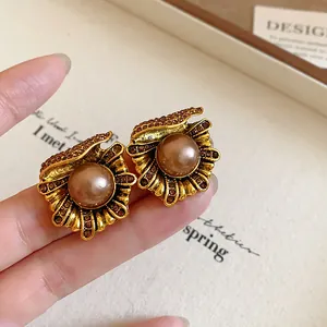 Detailed macro view of vintage flower earrings with brown pearl and shiny rhinestones