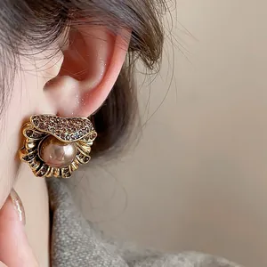 Detailed macro shot of a vintage palace-style gold flower pearl stud earring worn on an ear