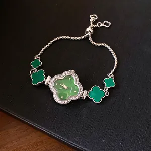 Elegante Detailansicht des grünen Kleeblatt-Zifferblatts mit funkelnder Strass-Lünette.