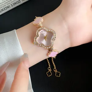 Nahaufnahme einer eleganten roségoldenen Kleeblatt-Uhr mit rosa Azetat-Zifferblatt