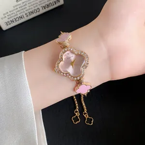 Nahaufnahme der eleganten blütenförmigen Uhr mit Strass und rosa Azetat-Akzenten