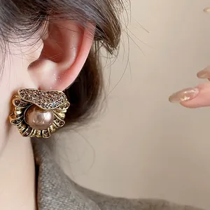 Close-up detail of a vintage irregular flower pearl earring set with shimmering brown crystals