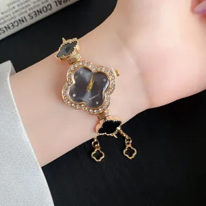 Elegante Armbanduhr mit Strasssteinen und schwarzen Kleeblatt-Details aus Acetat.