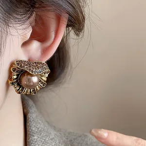 Vintage palace style flower earring detail with central pearl and inlaid rhinestones