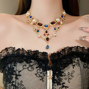 Vintage-style gold-plated teardrop necklace with blue rhinestones and pearls worn by a model