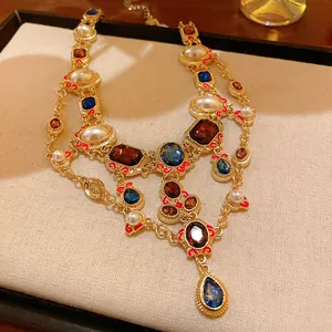 Detail view of vintage gold necklace with pearls and blue rhinestone drop pendant.
