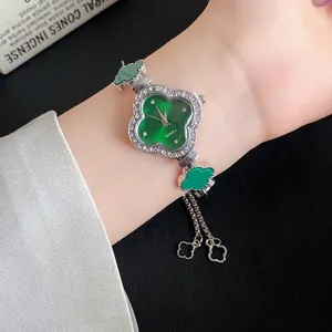 Nahaufnahme einer luxuriösen grünen vierblättrigen Kleeblatt-Armbanduhr mit Strass