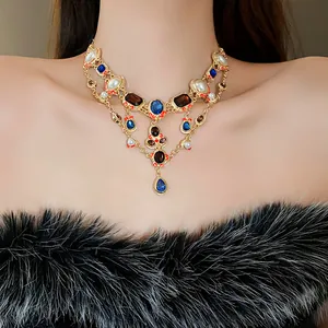 Macro view of a vintage gold necklace with blue rhinestones and pearls on a model