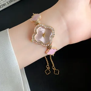 Nahaufnahme einer eleganten Armbanduhr in Roségold mit Kleeblatt-Design am Handgelenk.