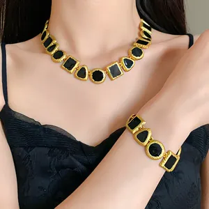 Close-up of vintage geometric enamel necklace and bracelet set in gold and black colors