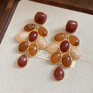 Primo piano dei dettagli degli orecchini vintage eleganti in resina marrone e oro
