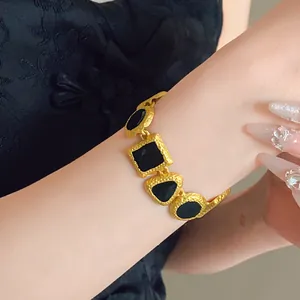 Detailed macro shot of vintage gold bracelet with black geometric enamel inlays