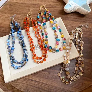 Detailed top-down view of four colorful Bohemian style double-layer irregular shell necklaces