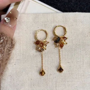 Detailed view of vintage hoop earrings with tiger's eye beads and pearl tassels