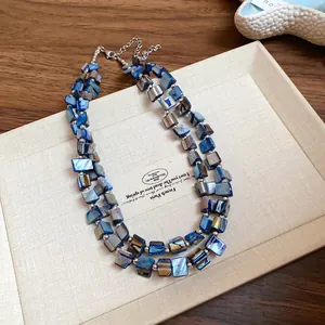 Macro detail of irregular double-layered blue shell necklace with bohemian charm