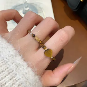 Vue détaillée d'une bague en perles d'œil de tigre avec un pendentif en cœur