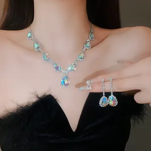 Dettaglio di una parure di gioielli con collana e orecchini in strass iridescenti.