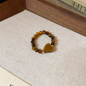 Vue détaillée d'une bague rétro en perles d'oeil de tigre avec un pendentif en forme de coeur