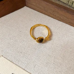 Vue détaillée de la pierre œil de tigre et du décor perlé sur la bague en or vintage
