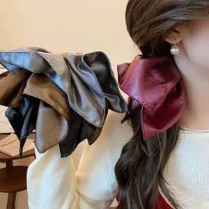 Detail shot of retro faux leather scrunchies in various colors for elegant ponytail styling.