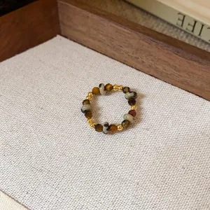 Vue rapprochée d'une bague en perles faite main avec œil de tigre et jaspe dalmatien