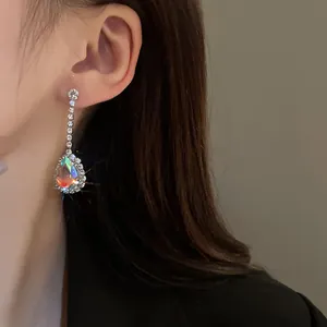 Primo piano dettagliato di eleganti orecchini a goccia con strass su modella per un look di lusso.