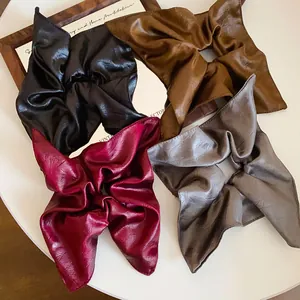 Macro shot of vintage style PU leather square scrunchies in four rich autumn colors