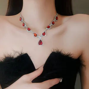 Primo piano di un'elegante collana con pietre rosse a goccia e strass lucenti