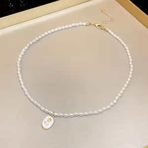 Primo piano di un'elegante collana di perle barocche stile francese con ciondolo floreale.