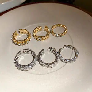 Vista dettagliata di anelli aperti regolabili con cuori e strass in oro e argento.