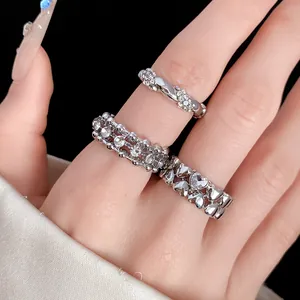Dettaglio di un set di tre anelli in strass argento con disegni a cuore e a treccia